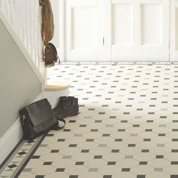 Geometric hallway floor tiles in black, white and grey with border edging tiles  